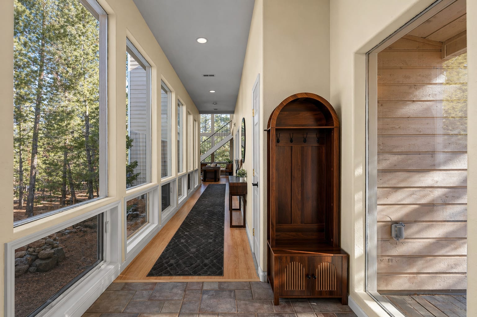 Bright entry hallway with windows on one side and coat hooks on the other