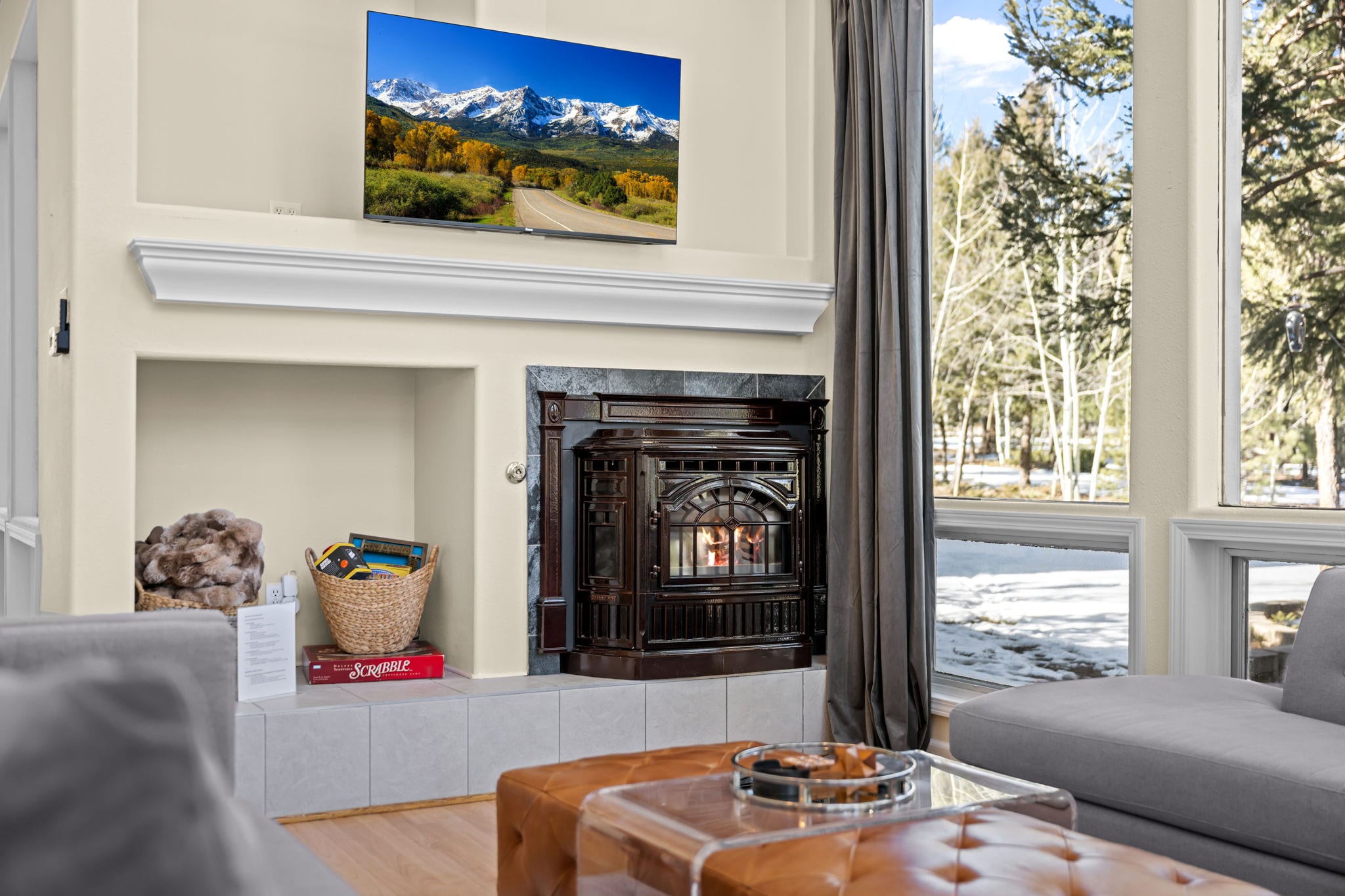 Living room fireplace and television framed by tall windows