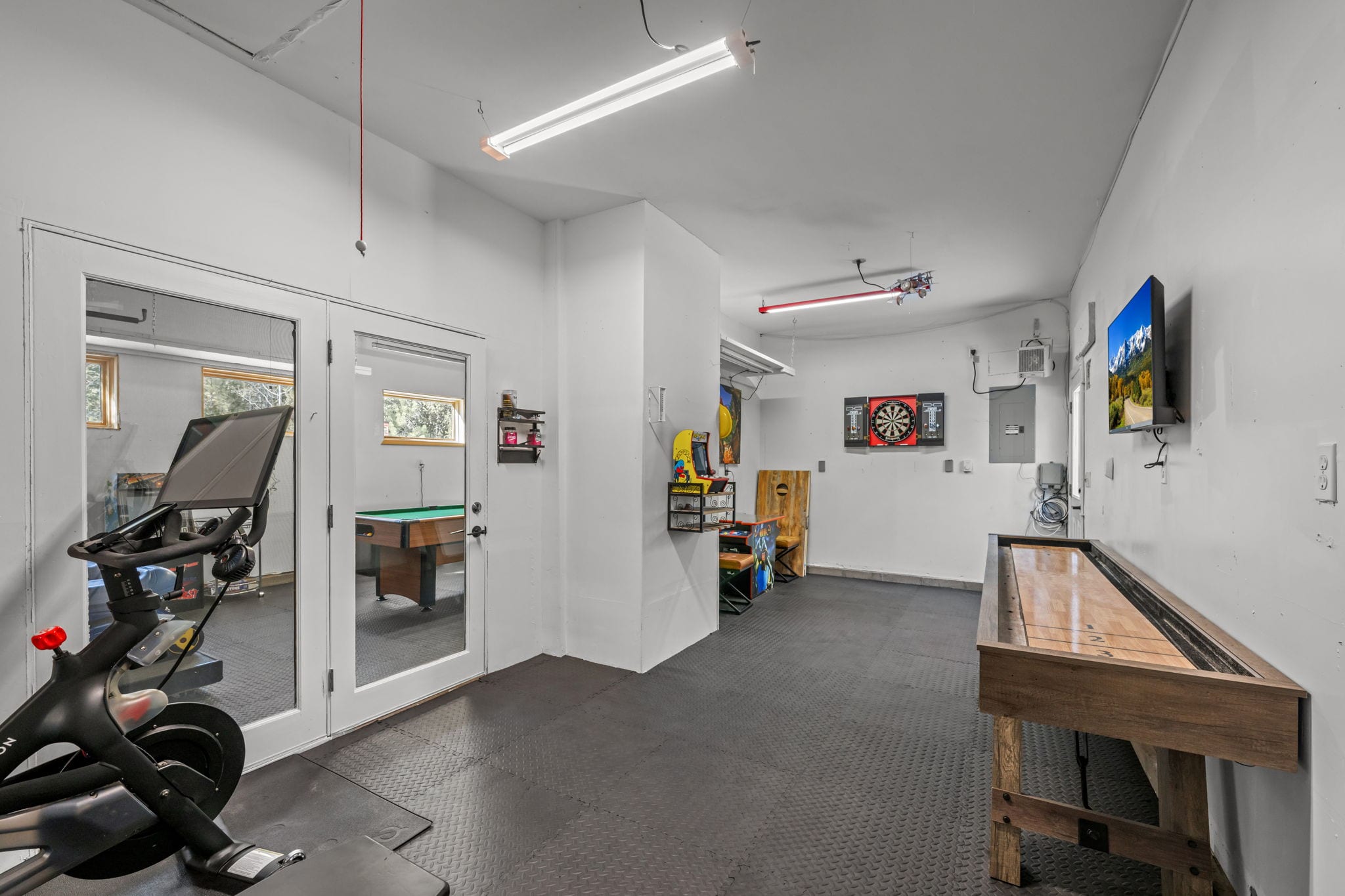 Game room with arcade machines, pool table and entertainment setup