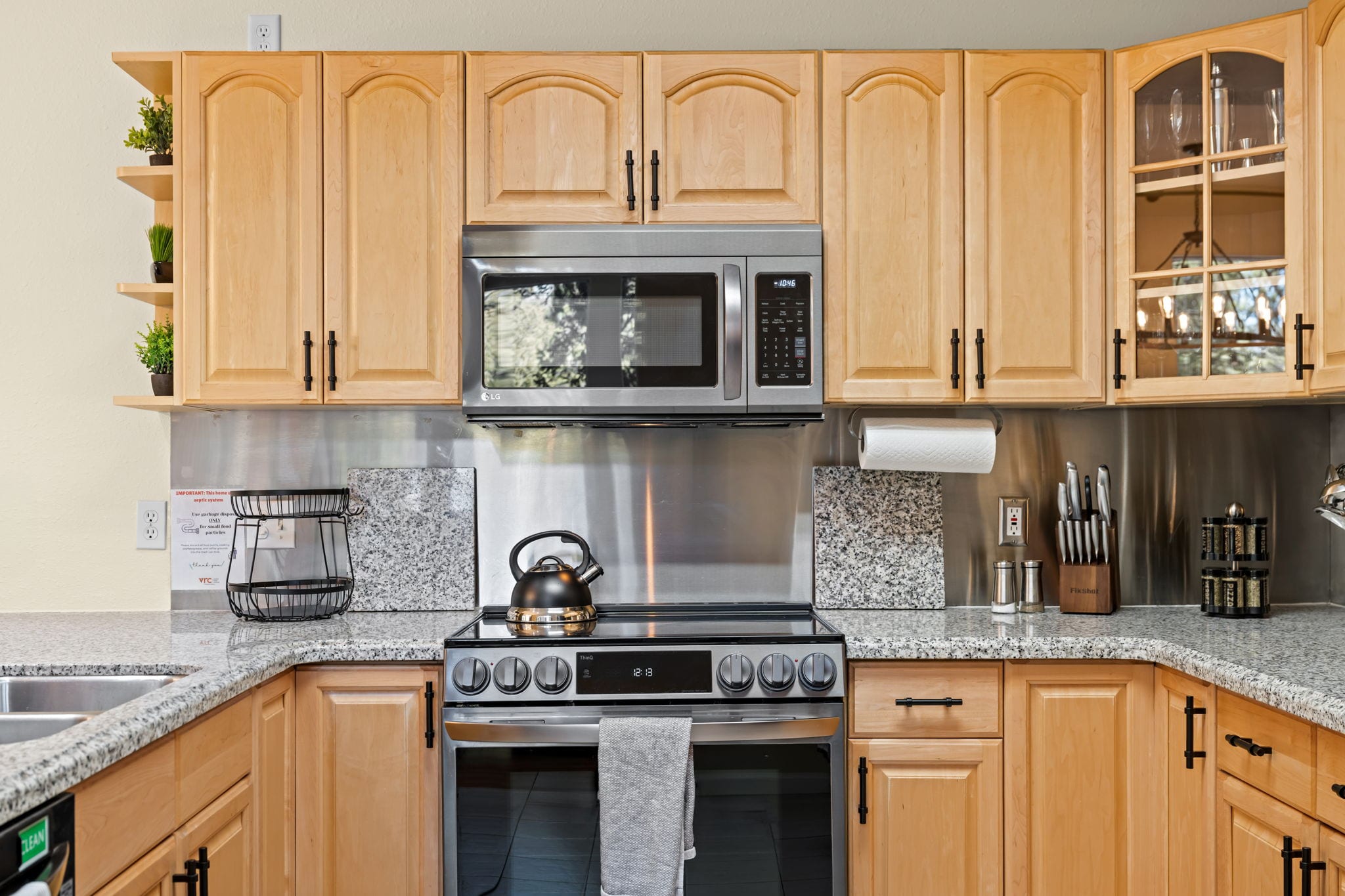 Fully equipped kitchen with stainless range and light wood cabinetry