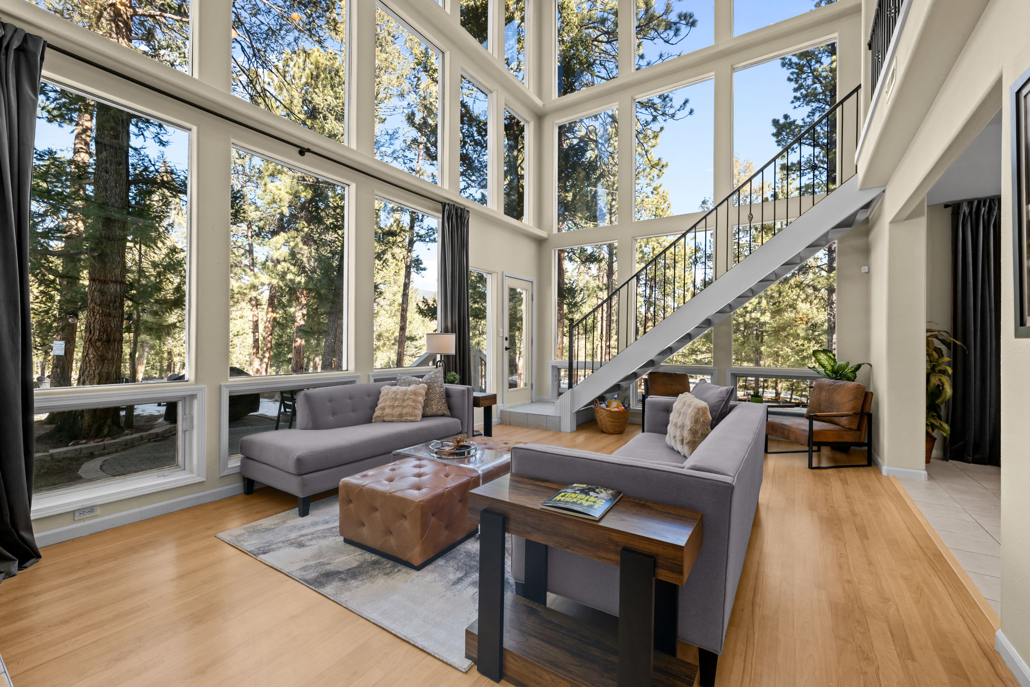 The Stillwood Retreat living room with two-story windows looking into the pines